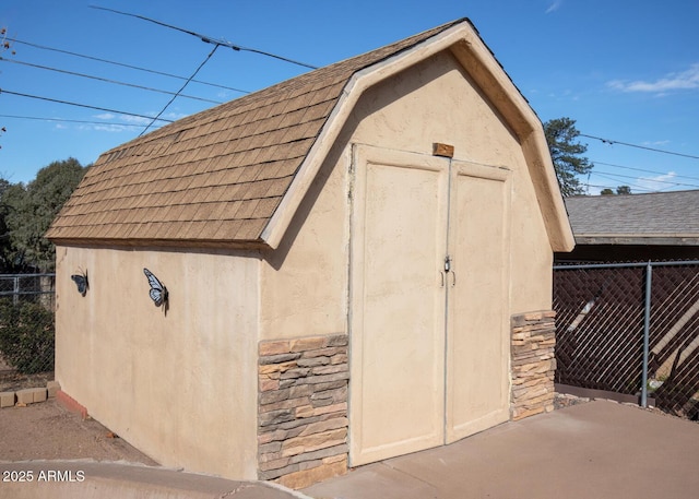 view of shed featuring fence