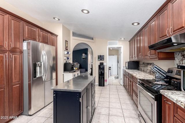 kitchen featuring stainless steel appliances, a kitchen island, and light tile patterned floors