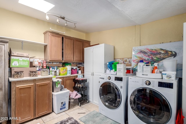 clothes washing area with light tile patterned floors, independent washer and dryer, and a skylight