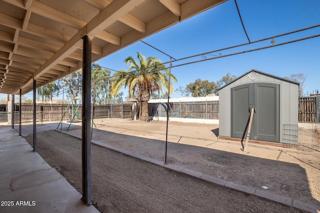 view of yard featuring a patio, a playground, and a shed