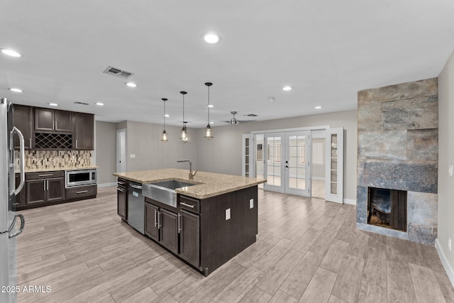 4602 W Monte Cristo Ave, Glendale, AZ 85306 - kitchen featuring a sink, appliances with stainless steel finishes, french doors, dark brown cabinets, and recessed lighting