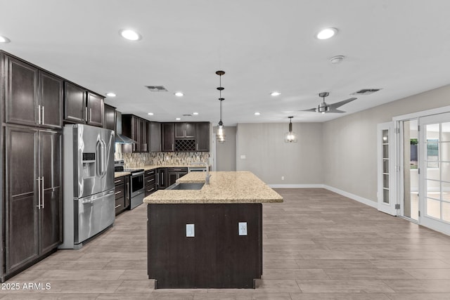 4602 W Monte Cristo Ave, Glendale, AZ 85306 - kitchen featuring stainless steel appliances, a center island with sink, recessed lighting, baseboards, and backsplash