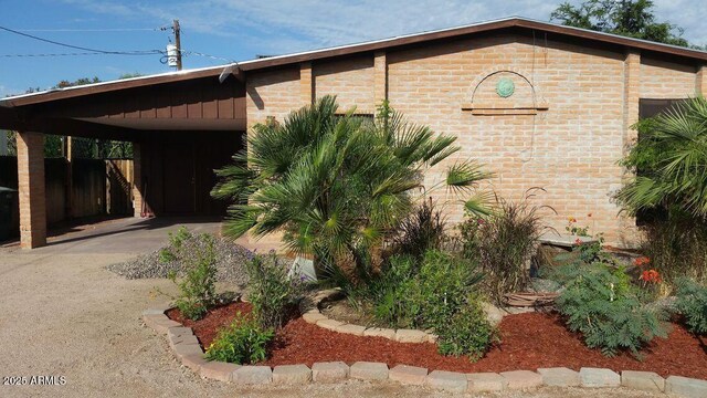 2534 N 52nd St, Phoenix, AZ 85008 - view of home's exterior featuring brick siding, a carport, and fence