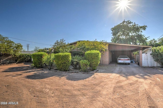 2534 N 52nd St, Phoenix, AZ 85008 - view of front facade featuring a carport, dirt driveway, fence, and a storage shed