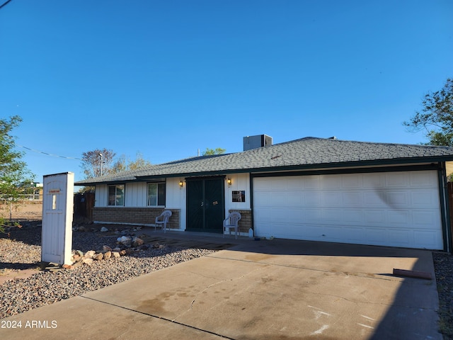 single story home with central AC and a garage