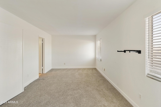 empty room featuring baseboards, carpet, and a healthy amount of sunlight