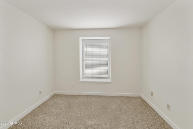 empty room with baseboards and light carpet