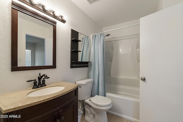 bathroom featuring toilet, vanity, a textured wall, and tile patterned floors
