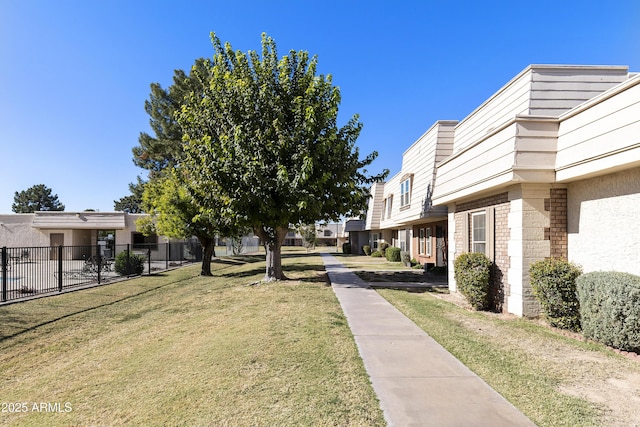 view of community with fence and a yard