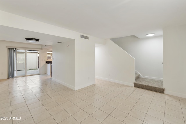 unfurnished living room with baseboards, visible vents, light tile patterned floors, and stairs