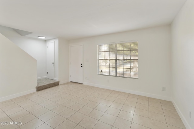unfurnished room featuring light tile patterned flooring and baseboards