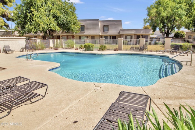 community pool with fence and a patio area
