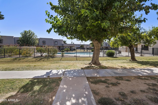 view of yard featuring fence and a community pool