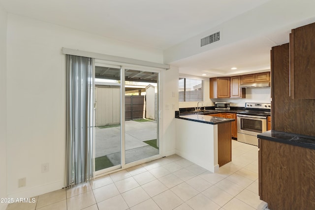kitchen featuring a sink, stainless steel appliances, under cabinet range hood, visible vents, and dark countertops
