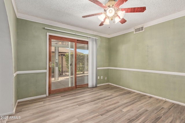 empty room with ceiling fan, light hardwood / wood-style flooring, a textured ceiling, and crown molding