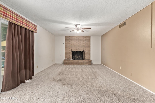 unfurnished living room featuring a fireplace, a textured ceiling, light carpet, and ceiling fan