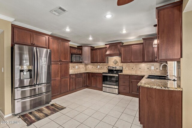 kitchen with custom exhaust hood, crown molding, appliances with stainless steel finishes, sink, and light stone counters