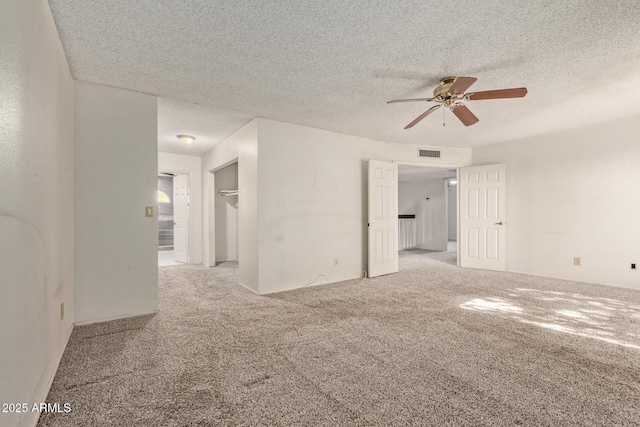 carpeted empty room featuring a textured ceiling and ceiling fan