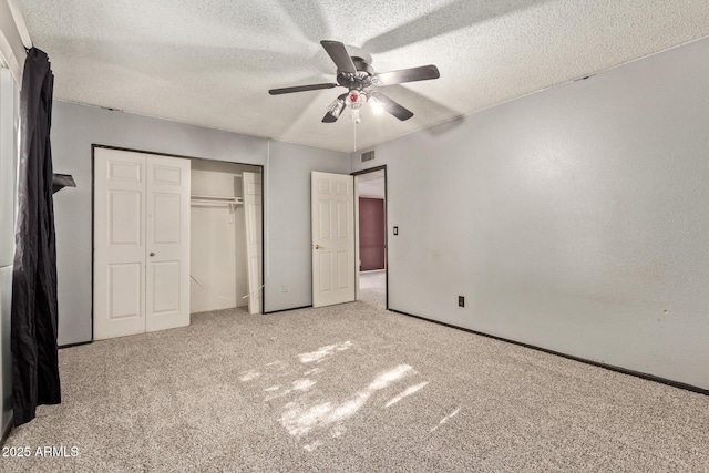 unfurnished bedroom with light carpet, a textured ceiling, and ceiling fan