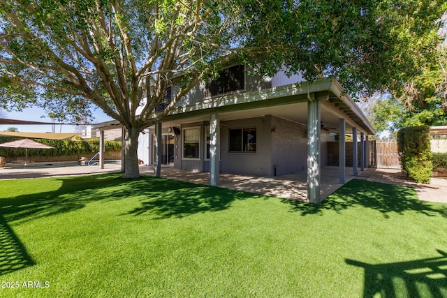 rear view of house featuring a yard and a patio