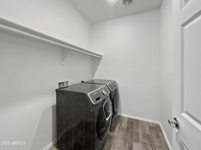 washroom featuring washing machine and dryer and hardwood / wood-style floors