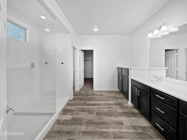 bathroom featuring wood-type flooring, vanity, and a shower