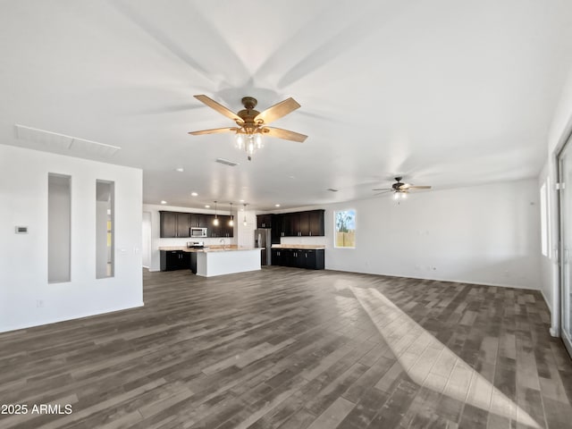 unfurnished living room with sink, dark wood-type flooring, and ceiling fan