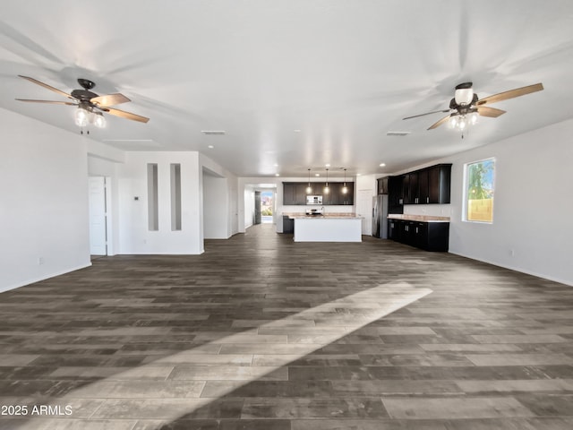 unfurnished living room with ceiling fan and dark hardwood / wood-style flooring