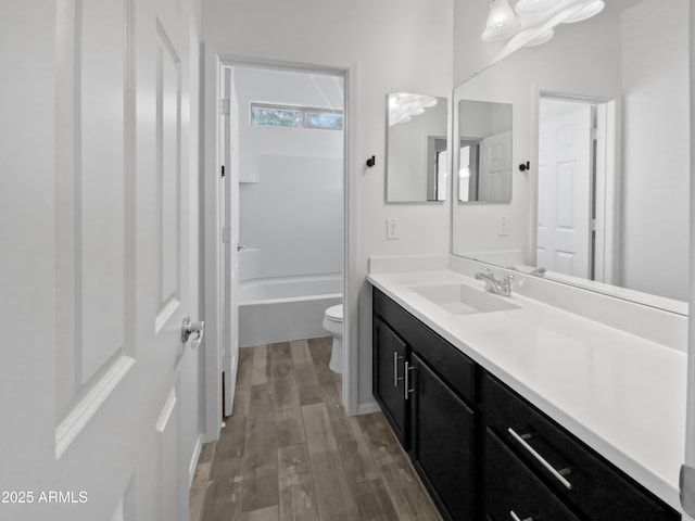 full bathroom with wood-type flooring, shower / bathing tub combination, vanity, and toilet