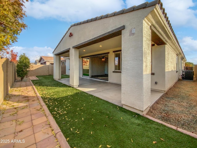 rear view of property with a patio, a yard, and central AC unit