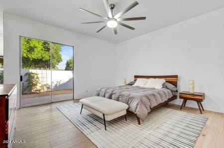 bedroom with light hardwood / wood-style floors, ceiling fan, and access to exterior