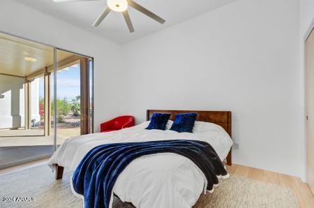 bedroom with wood-type flooring, ceiling fan, and access to outside