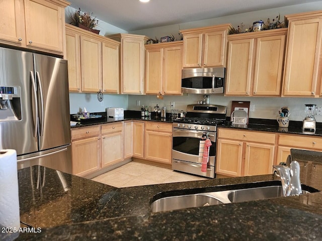 kitchen with a sink, light brown cabinetry, and stainless steel appliances