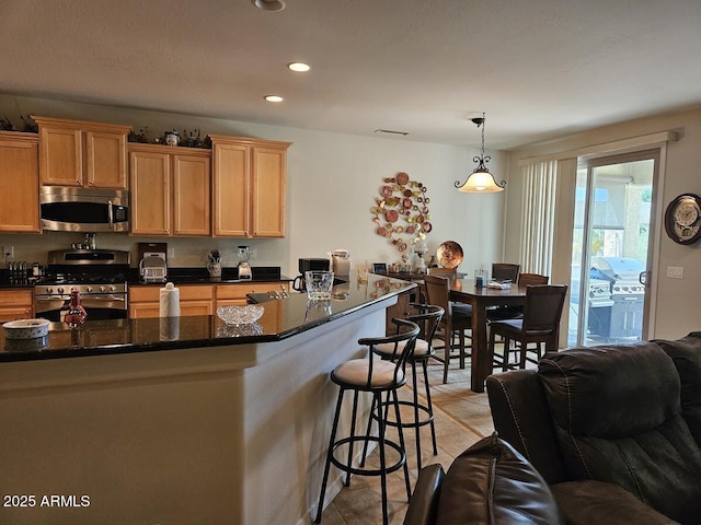 kitchen with visible vents, a breakfast bar, recessed lighting, decorative light fixtures, and stainless steel appliances