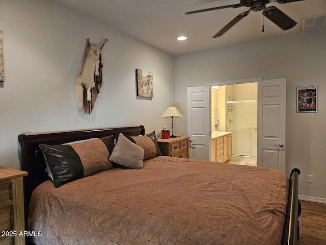 bedroom with visible vents, wood finished floors, baseboards, ensuite bathroom, and recessed lighting