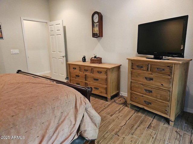 bedroom featuring wood tiled floor and baseboards