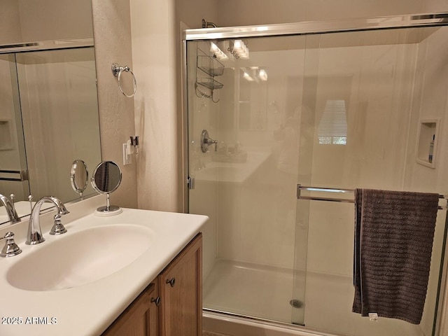 bathroom featuring a shower stall and vanity