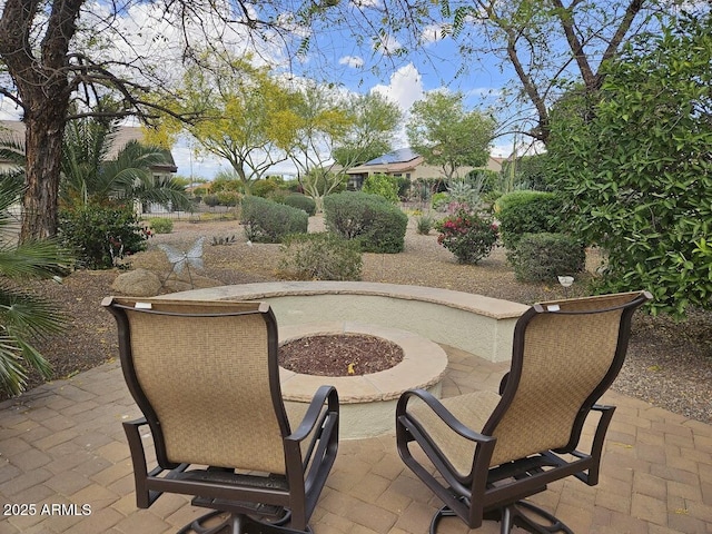 view of community with a patio and an outdoor fire pit