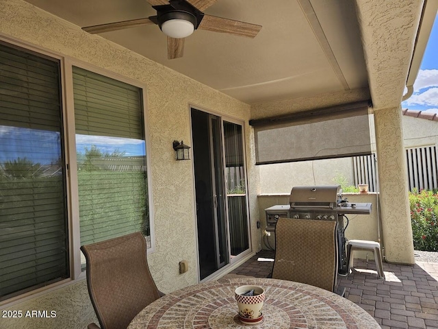 view of patio with outdoor dining area, ceiling fan, and a grill