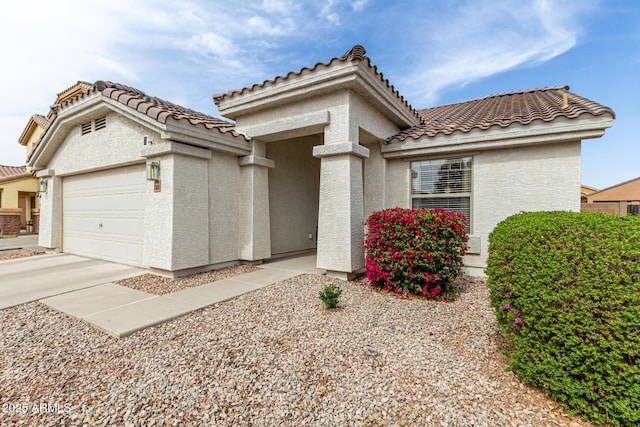 view of front of home with driveway, an attached garage, and stucco siding