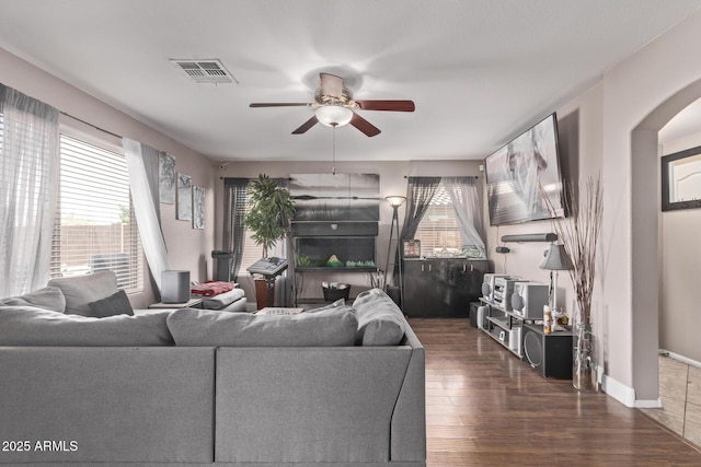 living room with wood finished floors, a healthy amount of sunlight, visible vents, and ceiling fan