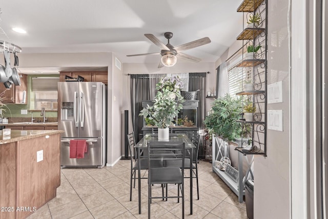 dining space featuring light tile patterned floors, baseboards, and ceiling fan