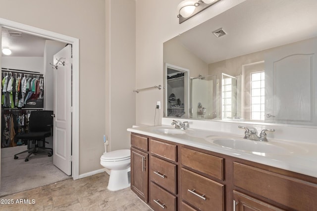 bathroom featuring a sink, visible vents, a walk in closet, and a stall shower