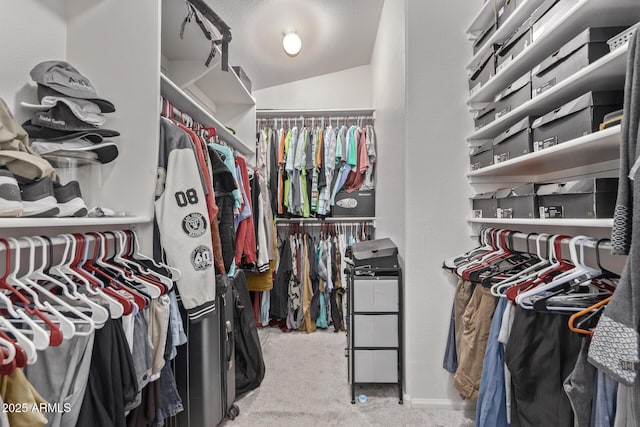 walk in closet featuring carpet flooring and lofted ceiling