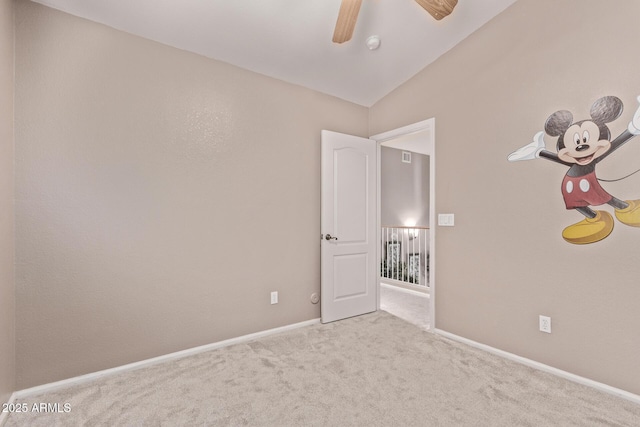 carpeted empty room featuring baseboards, a ceiling fan, and lofted ceiling