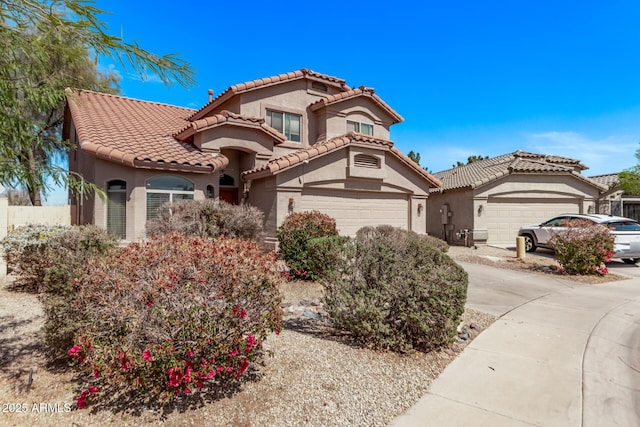 mediterranean / spanish house with a tile roof, concrete driveway, and stucco siding