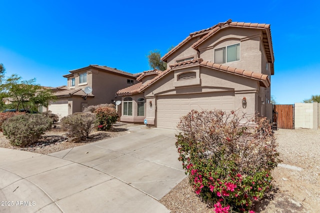 mediterranean / spanish home with a gate, fence, driveway, stucco siding, and a tile roof