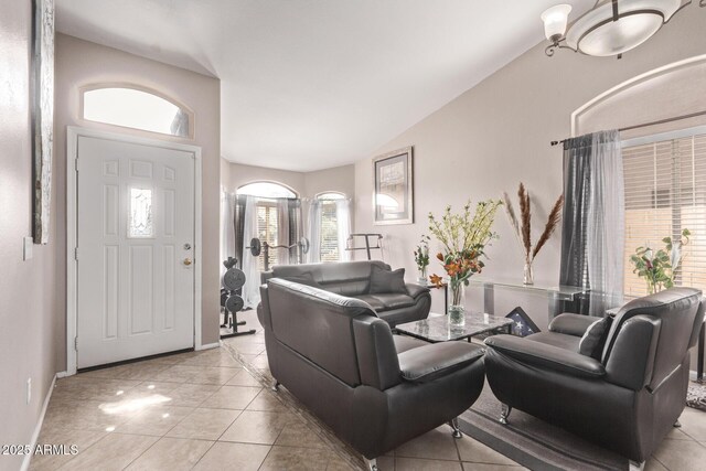 living area featuring light tile patterned flooring, baseboards, and vaulted ceiling