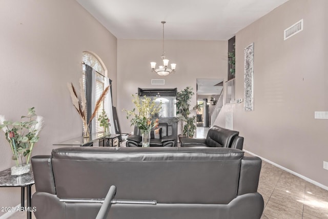 living area featuring a notable chandelier, stairway, baseboards, and visible vents