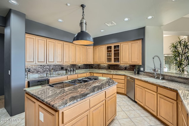 kitchen with a center island, sink, hanging light fixtures, stainless steel dishwasher, and dark stone countertops